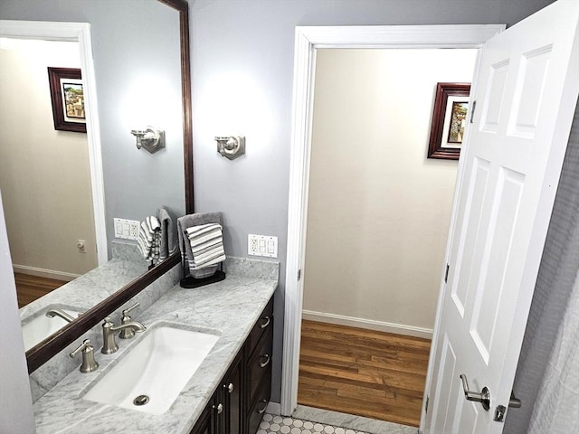 bathroom featuring vanity, wood finished floors, and baseboards