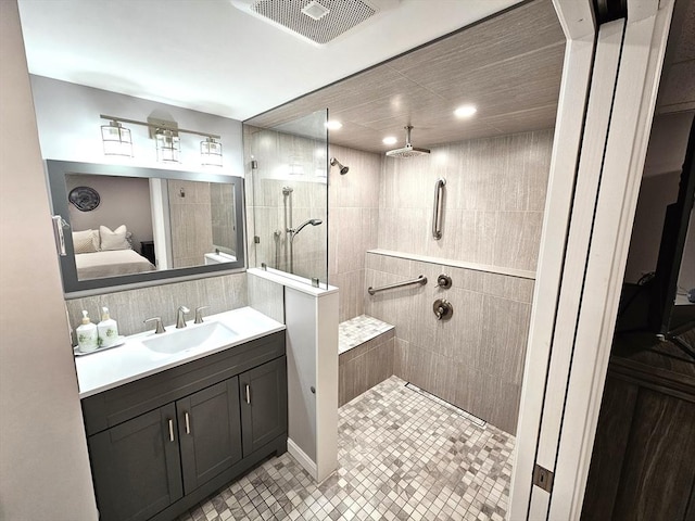 full bathroom with vanity, a walk in shower, visible vents, and ensuite bathroom