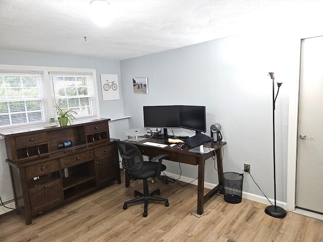 office space with baseboards, light wood finished floors, and a textured ceiling