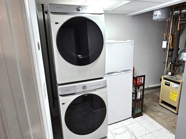 clothes washing area with laundry area, marble finish floor, and stacked washer / drying machine