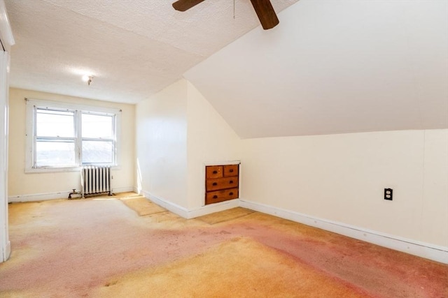 bonus room with radiator, carpet, baseboards, lofted ceiling, and a textured ceiling