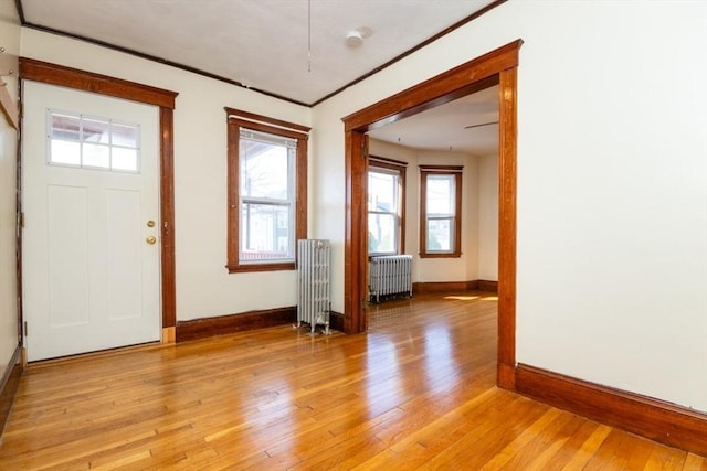 entrance foyer with light wood-style floors, radiator, and a healthy amount of sunlight