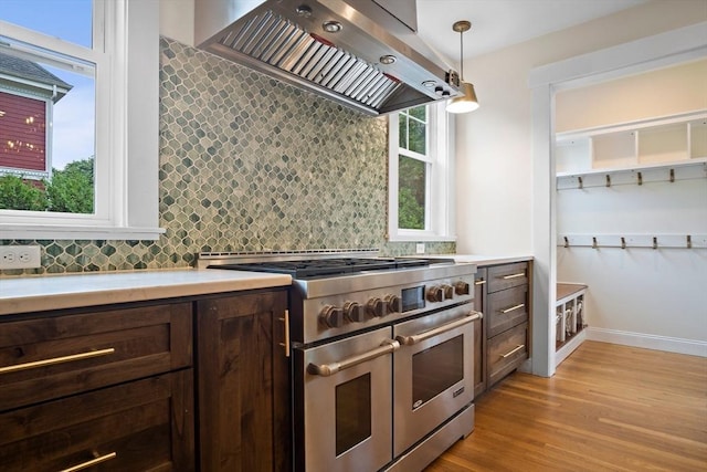 9 Arlington Rd, Woburn, MA 01801 - kitchen with range with two ovens, custom exhaust hood, dark brown cabinets, light countertops, and backsplash