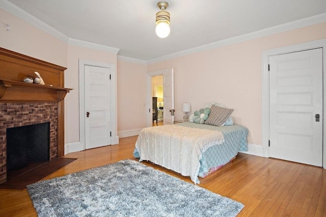 9 Arlington Rd, Woburn, MA 01801 - bedroom with light wood-style flooring, crown molding, and a brick fireplace