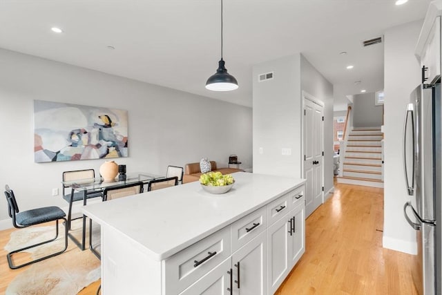 123-125 Centre St Unit Th4, Boston, MA 02124 - kitchen with freestanding refrigerator, white cabinetry, light wood-style flooring, and visible vents