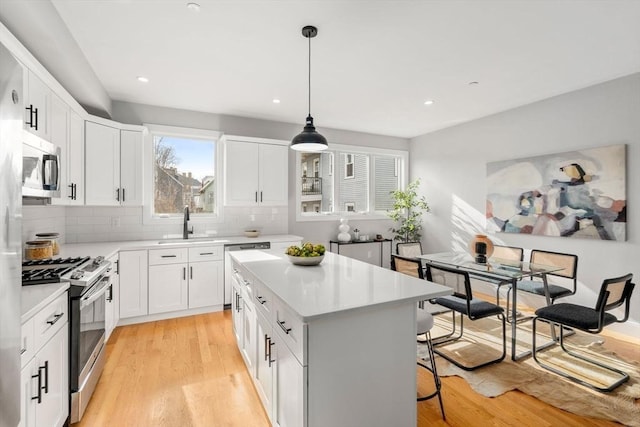 123-125 Centre St Unit Th4, Boston, MA 02124 - kitchen featuring a kitchen island, tasteful backsplash, light countertops, a breakfast bar, and stainless steel appliances
