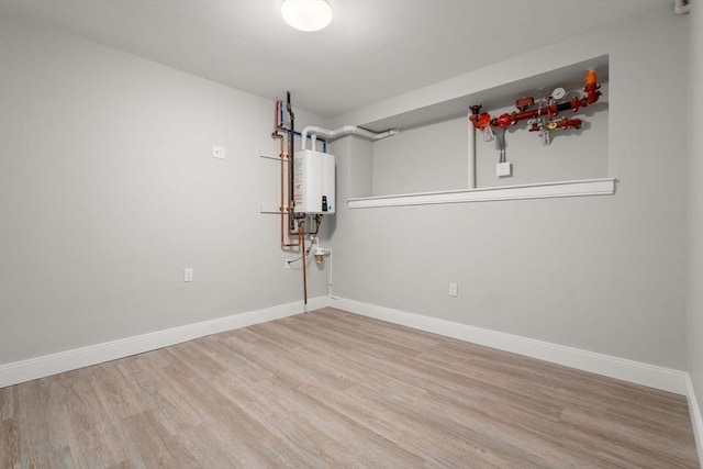 123-125 Centre St Unit Th4, Boston, MA 02124 - spare room featuring water heater, baseboards, and wood finished floors
