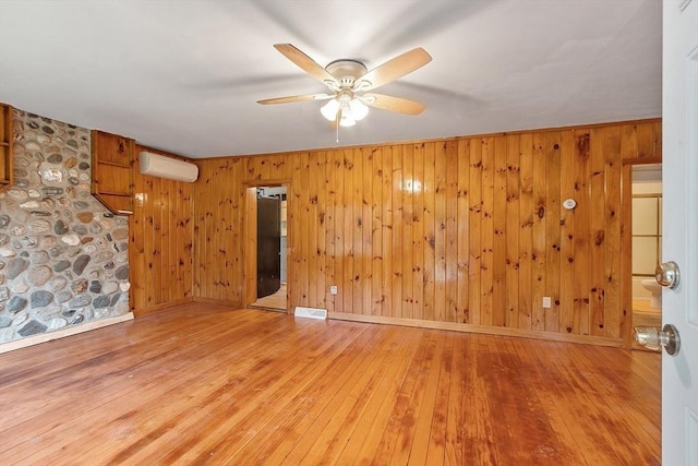 10 Worcester Rd, Townsend, MA 01469 - unfurnished room featuring a wall mounted air conditioner, a ceiling fan, wood-type flooring, wooden walls, and baseboards