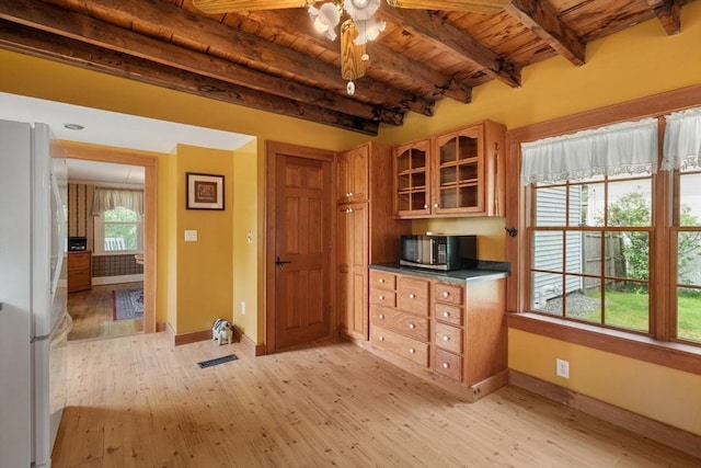 19 E St, Grafton, MA 01536 - kitchen with freestanding refrigerator, stainless steel microwave, a wood ceiling with exposed beams, light wood-type flooring, and glass insert cabinets