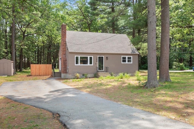 268 Pine St, Tewksbury, MA 01876 - view of front of property featuring a storage unit, a chimney, roof with shingles, asphalt driveway, and entry steps
