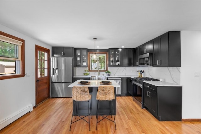 268 Pine St, Tewksbury, MA 01876 - kitchen featuring a baseboard radiator, appliances with stainless steel finishes, dark cabinets, light countertops, and glass insert cabinets
