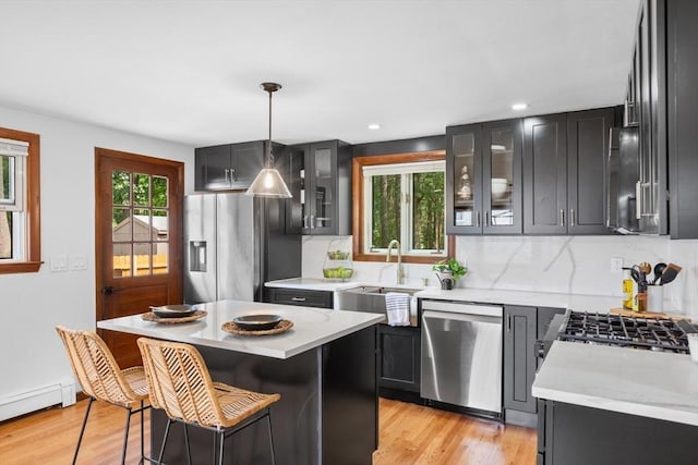 268 Pine St, Tewksbury, MA 01876 - kitchen with appliances with stainless steel finishes, a baseboard radiator, backsplash, light wood-style floors, and recessed lighting