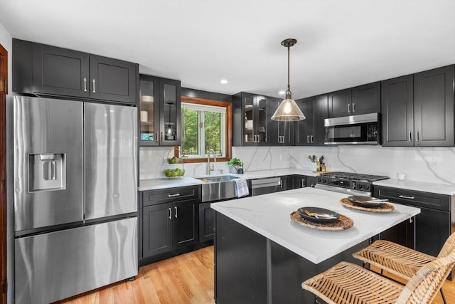 268 Pine St, Tewksbury, MA 01876 - kitchen featuring stainless steel appliances, glass insert cabinets, decorative backsplash, light wood finished floors, and decorative light fixtures
