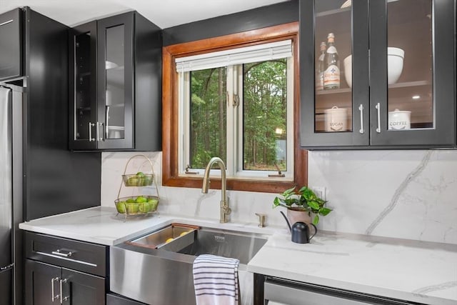 268 Pine St, Tewksbury, MA 01876 - kitchen featuring decorative backsplash, glass insert cabinets, light stone countertops, and dark cabinetry
