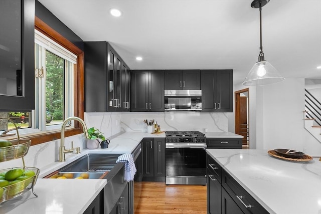 268 Pine St, Tewksbury, MA 01876 - kitchen with appliances with stainless steel finishes, dark cabinets, backsplash, recessed lighting, and hanging light fixtures