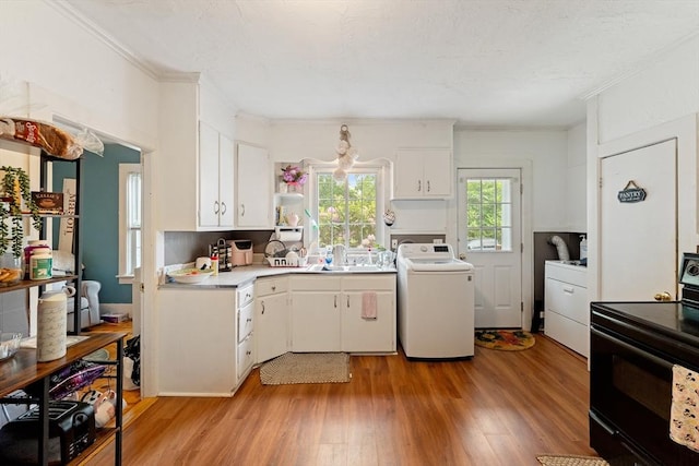 85 Everett St, Southbridge, MA 01550 - kitchen with washer / dryer, black range with electric cooktop, light wood finished floors, white cabinets, and ornamental molding