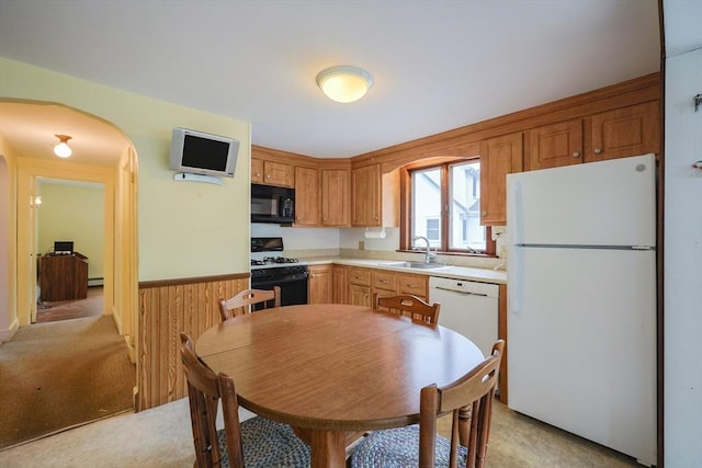 26 Presidents Rd, Weymouth, MA 02188 - kitchen with white appliances, a sink, arched walkways, light countertops, and light colored carpet