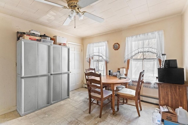 dining space featuring light floors, ceiling fan, baseboard heating, and crown molding