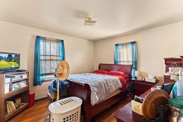 bedroom with a baseboard radiator and wood finished floors