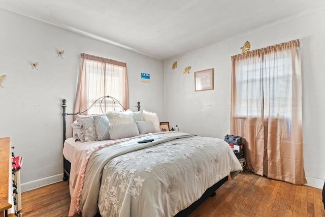 bedroom with baseboards and wood finished floors