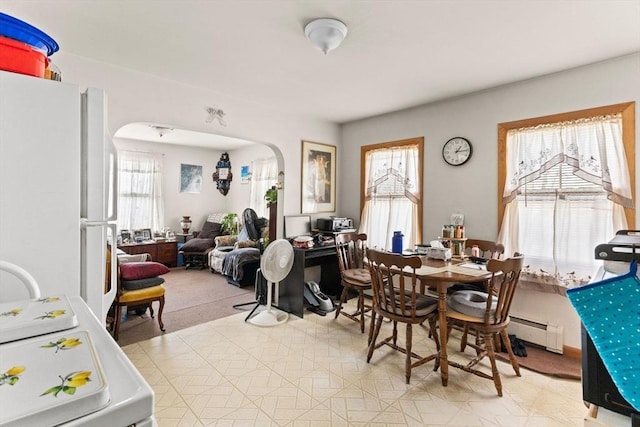 dining area with arched walkways and baseboard heating