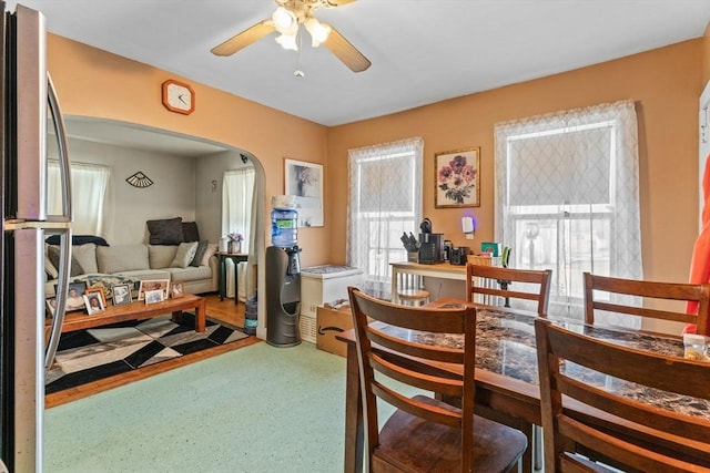 dining room with ceiling fan and arched walkways