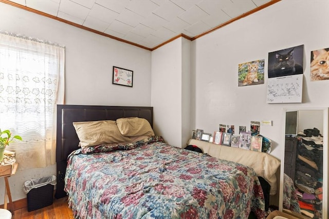 bedroom featuring crown molding and wood finished floors