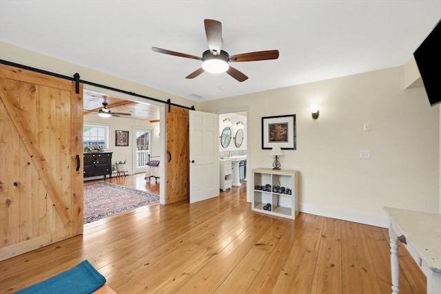 39 Cook Rd, Southampton, MA 01073 - unfurnished living room featuring a barn door, a ceiling fan, light wood finished floors, and baseboards