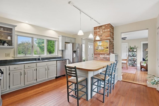 39 Cook Rd, Southampton, MA 01073 - kitchen featuring appliances with stainless steel finishes, a sink, rail lighting, light wood-type flooring, and a breakfast bar area