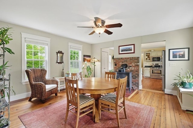 39 Cook Rd, Southampton, MA 01073 - dining space with a wood stove, light wood finished floors, a ceiling fan, and baseboards