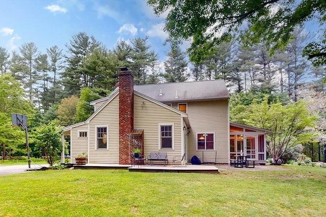 79 Charter Rd, Acton, MA 01720 - back of house with a deck, a sunroom, a chimney, and a lawn