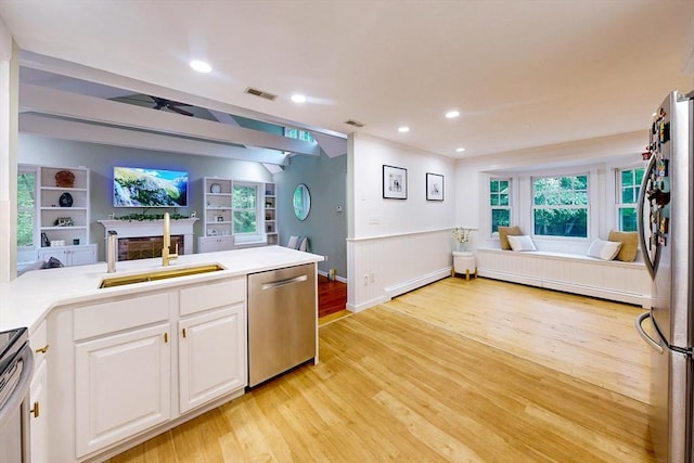 79 Charter Rd, Acton, MA 01720 - kitchen with appliances with stainless steel finishes, open floor plan, a sink, light wood finished floors, and wainscoting