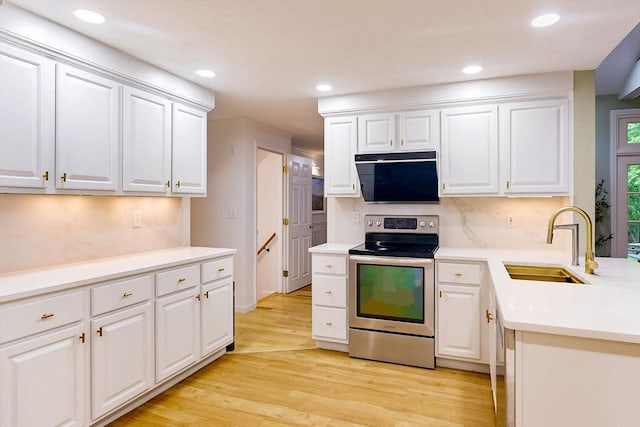 79 Charter Rd, Acton, MA 01720 - kitchen with stainless steel electric range oven, a sink, light wood finished floors, white cabinetry, and light countertops