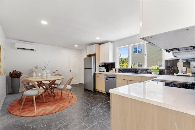 kitchen featuring light brown cabinets, sink, light stone countertops, a wall mounted AC, and stainless steel appliances