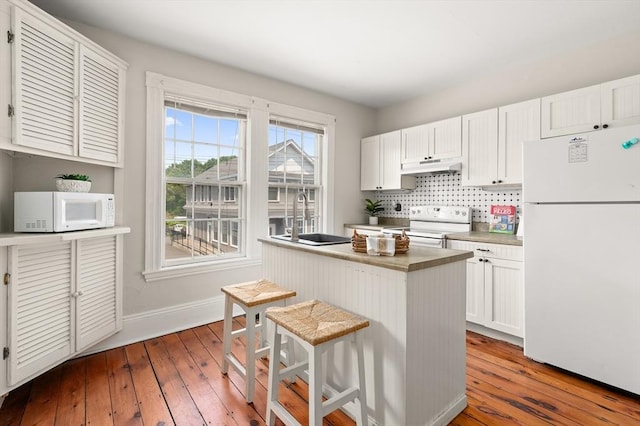148-150 Pleasant St Unit 2, Marblehead, MA 01945 - kitchen featuring white appliances, a sink, under cabinet range hood, baseboards, and hardwood / wood-style floors