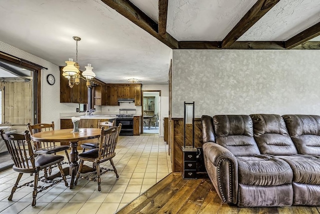 dining area featuring an inviting chandelier, beam ceiling, and light wood-style flooring