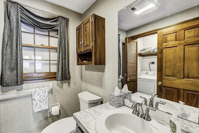 bathroom featuring visible vents, washer / dryer, toilet, and vanity