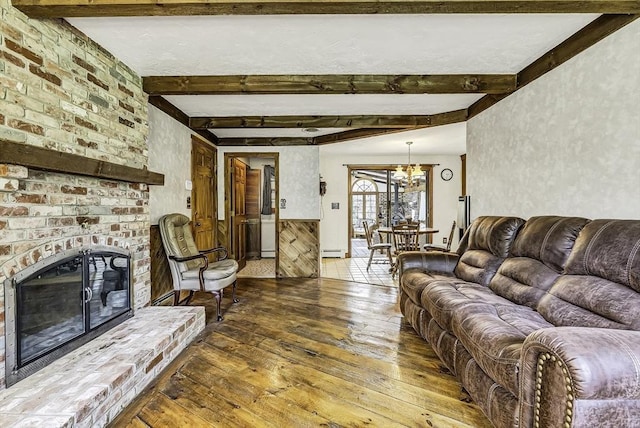 living room featuring a notable chandelier, a baseboard radiator, beam ceiling, and hardwood / wood-style floors