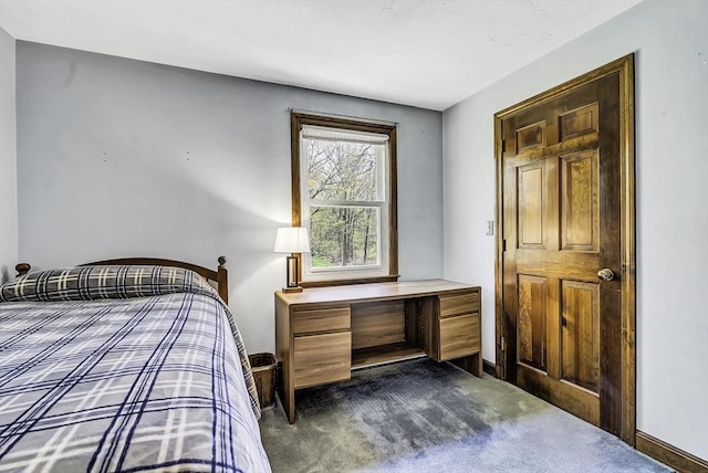 bedroom with baseboards and dark colored carpet