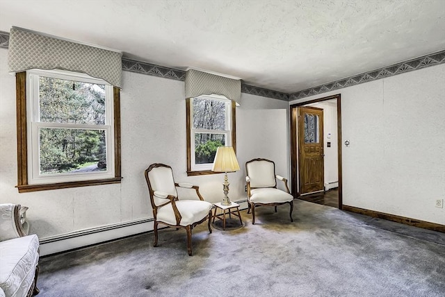sitting room with carpet floors, a textured ceiling, a textured wall, and a baseboard heating unit