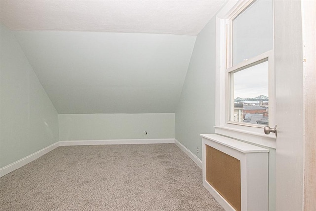 bonus room featuring light colored carpet and vaulted ceiling