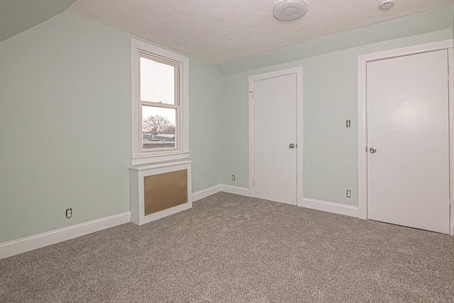 bonus room with carpet flooring and vaulted ceiling