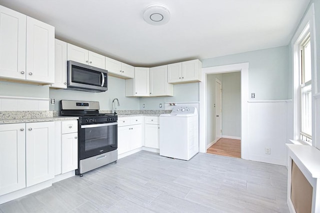 kitchen featuring white cabinets, appliances with stainless steel finishes, washer / clothes dryer, and a healthy amount of sunlight