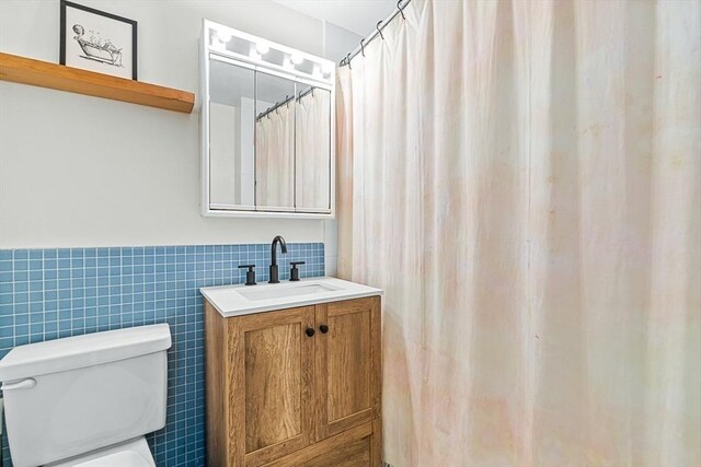 19 Winchester St Unit 102, Brookline, MA 02446 - full bathroom featuring tile walls, vanity, toilet, and a wainscoted wall