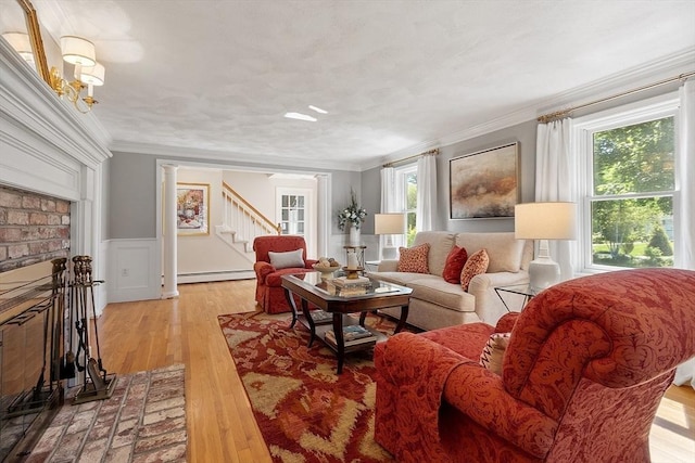 134 Reed Farm Rd, Boxborough, MA 01719 - living room with baseboard heating, stairway, light wood finished floors, a wainscoted wall, and crown molding