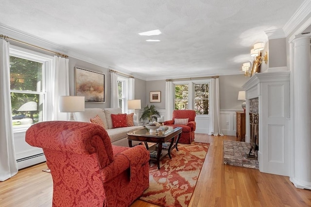 134 Reed Farm Rd, Boxborough, MA 01719 - living area featuring a baseboard radiator, light wood-style floors, a fireplace with raised hearth, ornamental molding, and a wainscoted wall