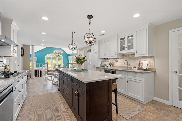 134 Reed Farm Rd, Boxborough, MA 01719 - kitchen with black stovetop, white cabinets, ornate columns, tasteful backsplash, and a breakfast bar area