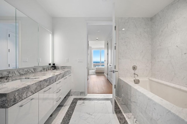 240 Devonshire St Unit 4210, Boston, MA 02110 - ensuite bathroom featuring a garden tub, double vanity, marble finish floors, and baseboards