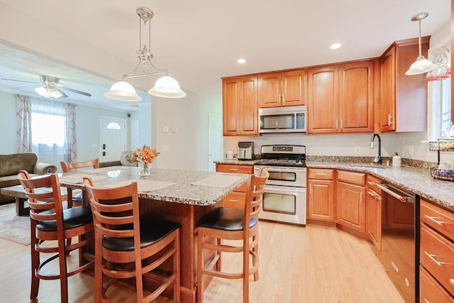421 Gray Ter, Dighton, MA 02764 - kitchen featuring appliances with stainless steel finishes, a sink, light wood-type flooring, light stone counters, and recessed lighting