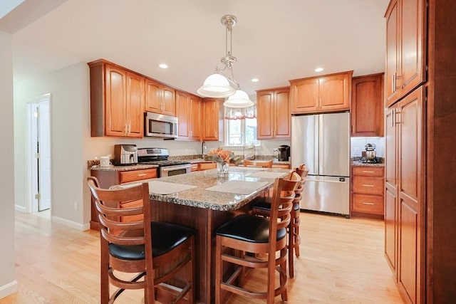 421 Gray Ter, Dighton, MA 02764 - kitchen with appliances with stainless steel finishes, light wood-type flooring, a kitchen bar, recessed lighting, and a kitchen island